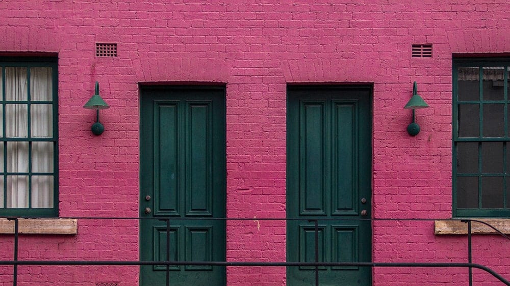 hot pink painted brownstone flat with cool old green doors and lights