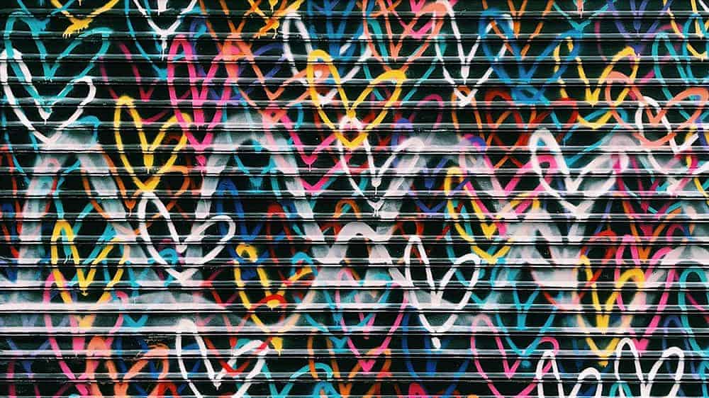 graffiti spray painted colorful hearts on a black metal wall - February 2022 wallpapers – 50 FREE calendars for your desktop & phone!