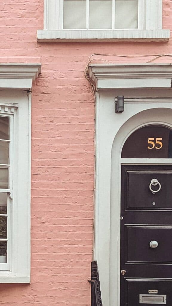 pretty pink painted brownstone flat with cool old black door