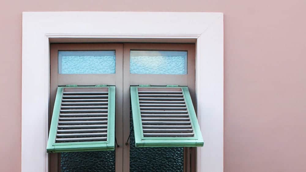 pink wall with green window shutters