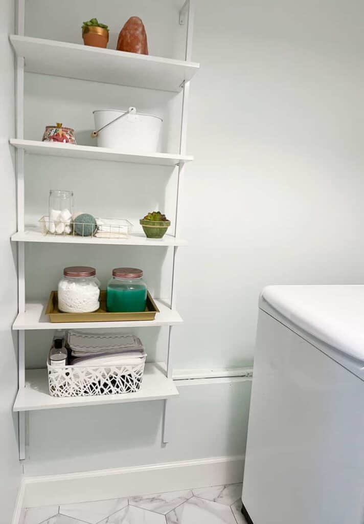 modern wall ladder storage shelf in laundry room - styled with decor and laundry items