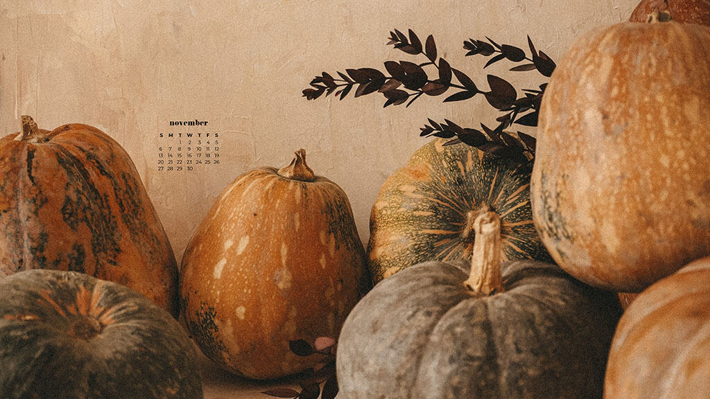 neutral textured background with muted orange, yellow, and green pumpkins and fall foliage November 2022 wallpapers – FREE calendars in Sunday & Monday starts + no-calendar designs. 59 beautiful options for desktop & smart phones!