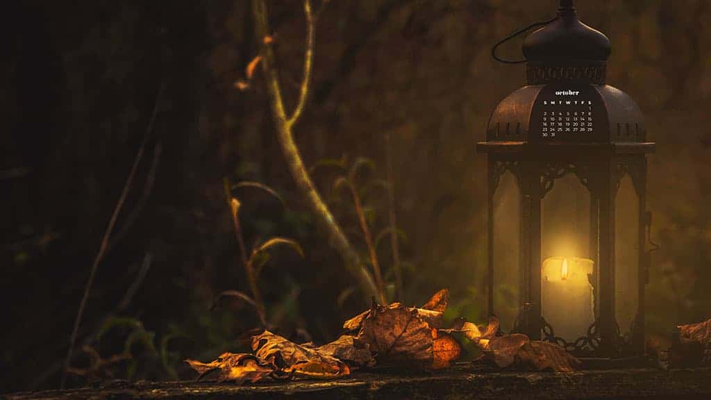 lantern with a candle in it next to leaves at dusk candy corn on turquoise background October 2022 wallpapers – FREE calendars in Sunday & Monday starts + no-calendar designs. 55 beautiful options for desktop & smart phones!