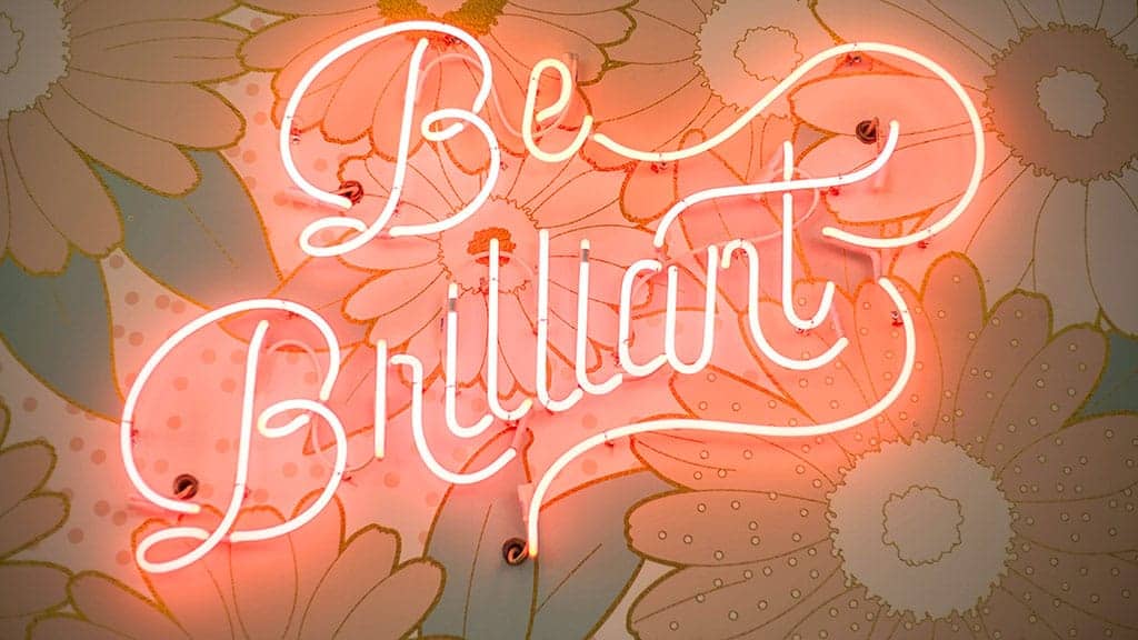 be brilliant neon sign on floral wallpaper