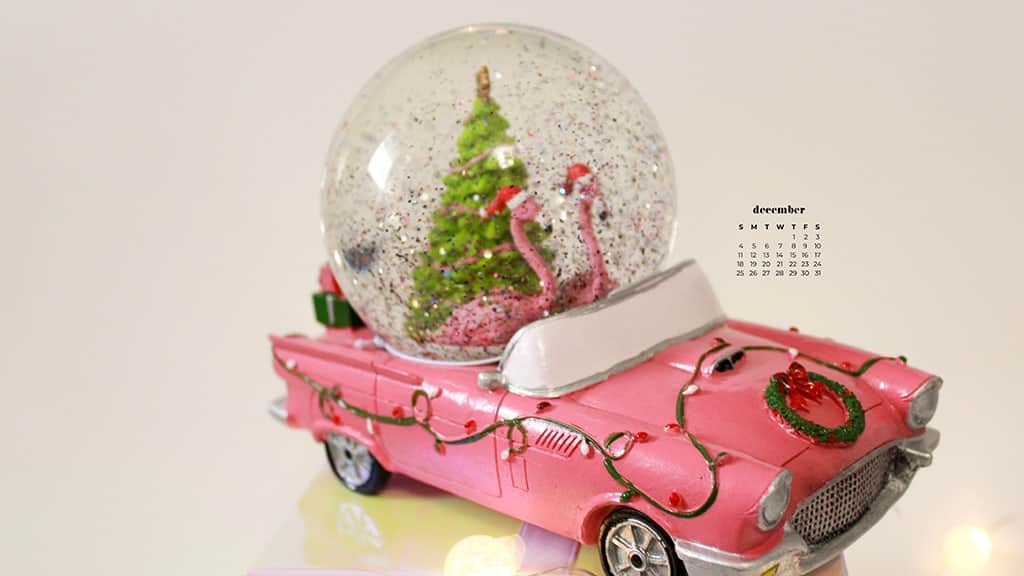 flamingo and christmas tree snow globe on top of a pink 57 chevy