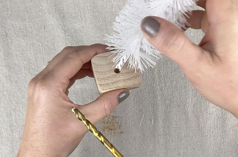 screw hole into wood base for bottle brush tree to sit inside